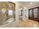 Elegant bathroom with a spacious walk-in shower, separate tub, and double doors at 10561 E Addy Way, Scottsdale, AZ 85262