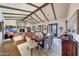An open floor plan reveals the living and dining rooms, featuring wood floors, a stone fireplace, and ample seating at 10561 E Addy Way, Scottsdale, AZ 85262