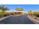 Exclusive community entrance with desert landscaping, flag, and signage at 10561 E Addy Way, Scottsdale, AZ 85262