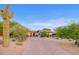 Desert home with mature landscaping, cactus, and brick driveway at 10561 E Addy Way, Scottsdale, AZ 85262