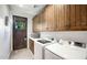 Functional laundry room with modern appliances, wooden cabinets and exterior door at 10561 E Addy Way, Scottsdale, AZ 85262