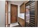 Laundry area with wooden cabinets, a wine fridge, and an adjacent laundry room at 10561 E Addy Way, Scottsdale, AZ 85262