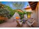 Cozy outdoor patio featuring a fireplace, comfortable seating, and lush landscaping at 10561 E Addy Way, Scottsdale, AZ 85262