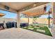 Inviting backyard oasis with pool, hot tub, covered patio, and artificial grass at 10780 W Woodland Ave, Avondale, AZ 85323