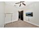 Bedroom featuring carpet, ceiling fan, TV mounted on the wall and black door at 10780 W Woodland Ave, Avondale, AZ 85323