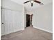 Bedroom featuring neutral carpet and walls and a black door to an adjoining bathroom at 10780 W Woodland Ave, Avondale, AZ 85323