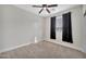 Bright bedroom featuring neutral walls, carpet, ceiling fan, and black window curtains at 10780 W Woodland Ave, Avondale, AZ 85323