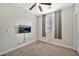 Cozy bedroom with ceiling fan, neutral carpet, and a TV mounted on the wall at 10780 W Woodland Ave, Avondale, AZ 85323