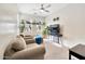 Brightly lit living area, with three plush armchairs, lots of windows, and neutral decor at 10780 W Woodland Ave, Avondale, AZ 85323