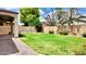 Large backyard with green grass, privacy fence, and covered patio area at 11106 E Serafina Ave, Mesa, AZ 85212