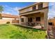 Well-kept backyard with covered patio, lush green lawn, and block wall for privacy at 11106 E Serafina Ave, Mesa, AZ 85212