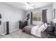 Serene bedroom with a ceiling fan, dresser, and comfortable bed near a window at 11106 E Serafina Ave, Mesa, AZ 85212