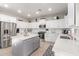 Modern kitchen boasts white cabinets, stainless steel appliances, a gray island, and tile backsplash at 11106 E Serafina Ave, Mesa, AZ 85212