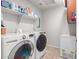 Convenient laundry room equipped with modern washer, dryer, and shelving for storage at 11106 E Serafina Ave, Mesa, AZ 85212