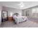 Serene main bedroom features plush carpeting, a ceiling fan, and two windows with natural light at 11106 E Serafina Ave, Mesa, AZ 85212