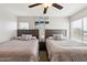Bedroom with two beds, soft carpet and ceiling fan, flooded with natural light from large windows at 11260 N 92Nd St # 2025, Scottsdale, AZ 85260