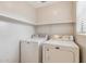 Functional laundry room with washer, dryer, and shelving, with natural light from a window at 11260 N 92Nd St # 2025, Scottsdale, AZ 85260