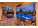An inviting back patio with seating, a ceiling fan and a beautiful illuminated pool and waterfalls at 13221 W Rincon Dr, Sun City West, AZ 85375
