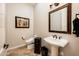 Powder bathroom features a unique pedestal sink and decorative wall art at 13221 W Rincon Dr, Sun City West, AZ 85375