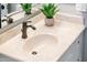 Bathroom vanity with a sink, dark faucet, neutral counters, and stylish decor, creating a sophisticated space at 13221 W Rincon Dr, Sun City West, AZ 85375