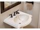 Stylish pedestal sink with bronze faucet and detailed mirror enhances the bathroom's aesthetic at 13221 W Rincon Dr, Sun City West, AZ 85375