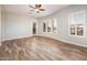 Bright bedroom features wood-look tile floors, neutral walls, and plantation shutters on the windows at 13221 W Rincon Dr, Sun City West, AZ 85375