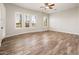 Bright bedroom features wood-look tile floors, neutral walls, and plantation shutters on the windows at 13221 W Rincon Dr, Sun City West, AZ 85375