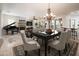 Elegant dining room with modern chandelier, black dining table, and access to the living area at 13221 W Rincon Dr, Sun City West, AZ 85375