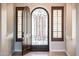 Bright foyer featuring tile flooring, arched doorway, and a decorative wrought iron screen door at 13221 W Rincon Dr, Sun City West, AZ 85375