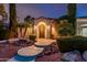 Inviting front entrance featuring arched doorway, lush landscaping, and stone accents at 13221 W Rincon Dr, Sun City West, AZ 85375