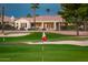 A beautiful golf course view shows the rear of the home surrounded by mature palm trees at 13221 W Rincon Dr, Sun City West, AZ 85375