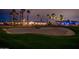 Sand trap on golf course with view of homes at night surrounded by palm trees at 13221 W Rincon Dr, Sun City West, AZ 85375