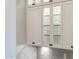 Bright kitchen with white cabinets and glass doors displaying glasses at 13221 W Rincon Dr, Sun City West, AZ 85375