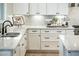 Kitchen sink area with granite countertops, white cabinets, and stainless steel sink at 13221 W Rincon Dr, Sun City West, AZ 85375