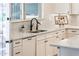 Kitchen sink area with granite countertops, white cabinets, and a modern faucet at 13221 W Rincon Dr, Sun City West, AZ 85375