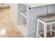 White kitchen island with open shelves and bar stool at 13221 W Rincon Dr, Sun City West, AZ 85375
