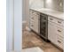 Wine refrigerator built into the white cabinets with granite countertops at 13221 W Rincon Dr, Sun City West, AZ 85375