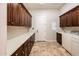 Spacious laundry room with ample counter space, wood cabinetry, and a washer and dryer at 13221 W Rincon Dr, Sun City West, AZ 85375