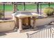 Outdoor fireplace with stone pillars, stucco finish, and surrounding landscaping at 13221 W Rincon Dr, Sun City West, AZ 85375