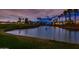 Back view of a pond on the golf course with homes and palm trees in the background at dusk at 13221 W Rincon Dr, Sun City West, AZ 85375