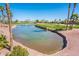 Scenic golf course pond with a fountain, surrounded by lush landscaping and beautiful homes at 13221 W Rincon Dr, Sun City West, AZ 85375