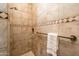 Elegant tiled shower with a bench, shower niche, and decorative accent tiles at 13221 W Rincon Dr, Sun City West, AZ 85375