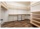 Spacious walk-in closet with custom shelving and wood-look floors at 13221 W Rincon Dr, Sun City West, AZ 85375