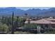 View of the exterior of a home with a tile roof, desert landscaping, and a backdrop of scenic mountain views at 13227 N Mimosa Dr # 107, Fountain Hills, AZ 85268