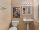 This half bathroom features a pedestal sink, decorative mirror, and themed wall art at 13227 N Mimosa Dr # 107, Fountain Hills, AZ 85268