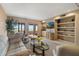 Bright living room with sliding glass doors, balcony, built-in shelves, and a flatscreen TV at 13227 N Mimosa Dr # 107, Fountain Hills, AZ 85268