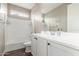 Bright bathroom features a single sink vanity, a large mirror, neutral paint, and a shower-tub combination at 13603 W Remuda Dr, Peoria, AZ 85383