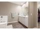 Bathroom featuring a tub, white cabinetry with dual sinks, and tile flooring at 13603 W Remuda Dr, Peoria, AZ 85383