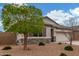 Inviting single-story home featuring stone accents, low-maintenance landscaping, and an attached two-car garage at 13603 W Remuda Dr, Peoria, AZ 85383