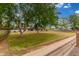 View of spacious front yard with mature trees and a well-maintained lawn leading to a beautiful single-story home at 13603 W Remuda Dr, Peoria, AZ 85383